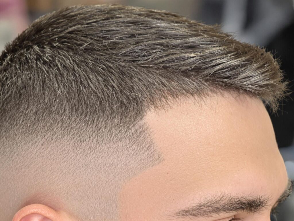 Man with sharp low taper fade hairstyle.